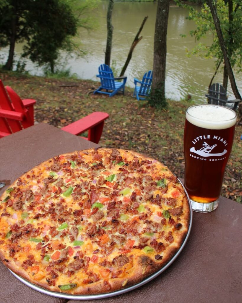 Little Miami Brewing Company’s Big Country Breakfast Supreme Pizza with a stout beer on the outdoor patio.