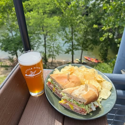 Craft beer, sandwich, and chips served on an outdoor riverside table at Little Miami Brewing Company.