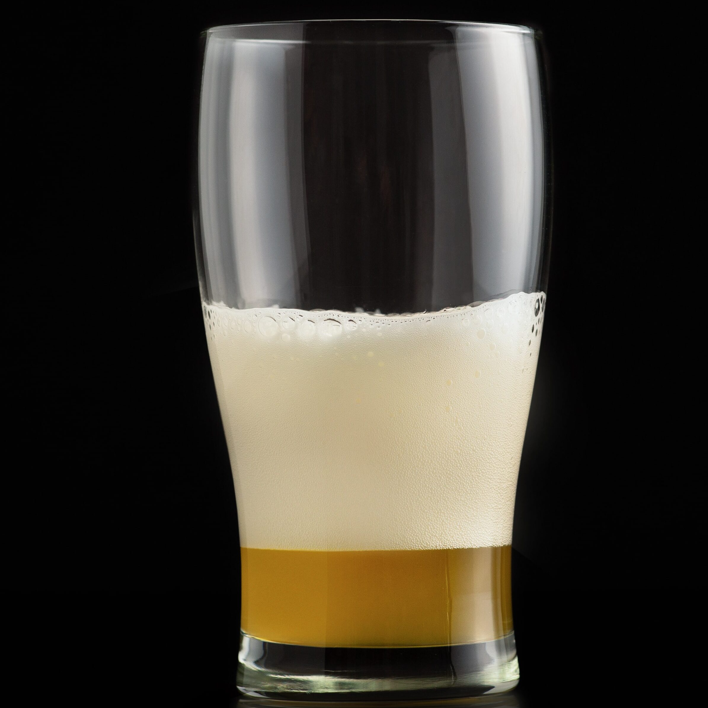 A glass of beer with a creamy foam layer, capturing the essence of a brew with moderate alcohol content. Understanding alcohol content in beers helps in choosing the right beverage strength for different occasions.