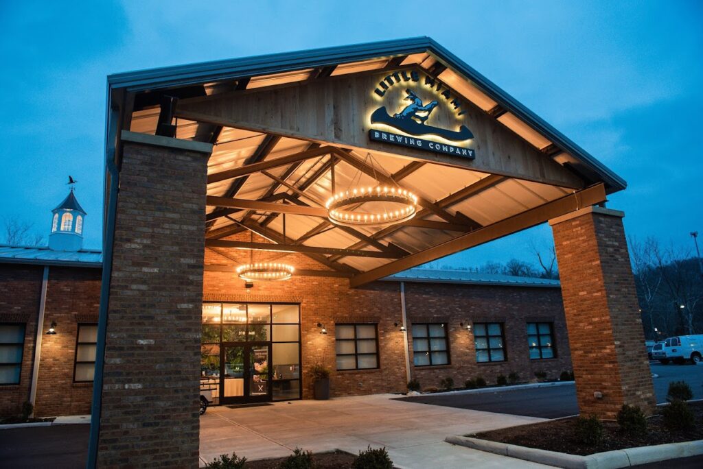 The brick building of Little Miami Brewing Company illuminated at dusk.