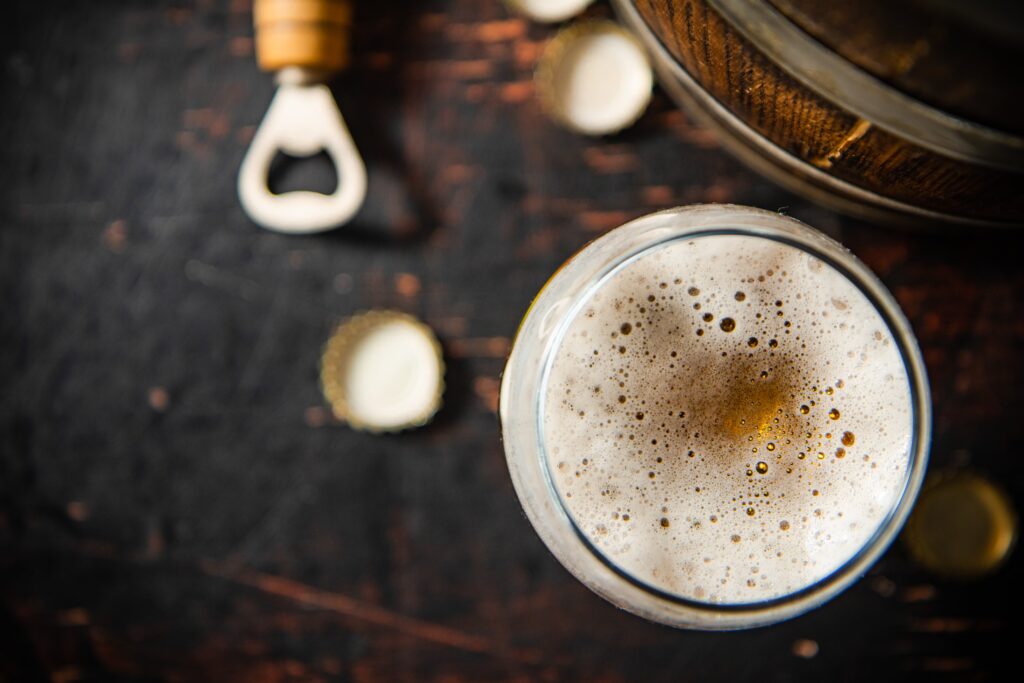 A frothy glass of beer on a rustic table, showcasing Little Miami Breweries in Cincinnati.