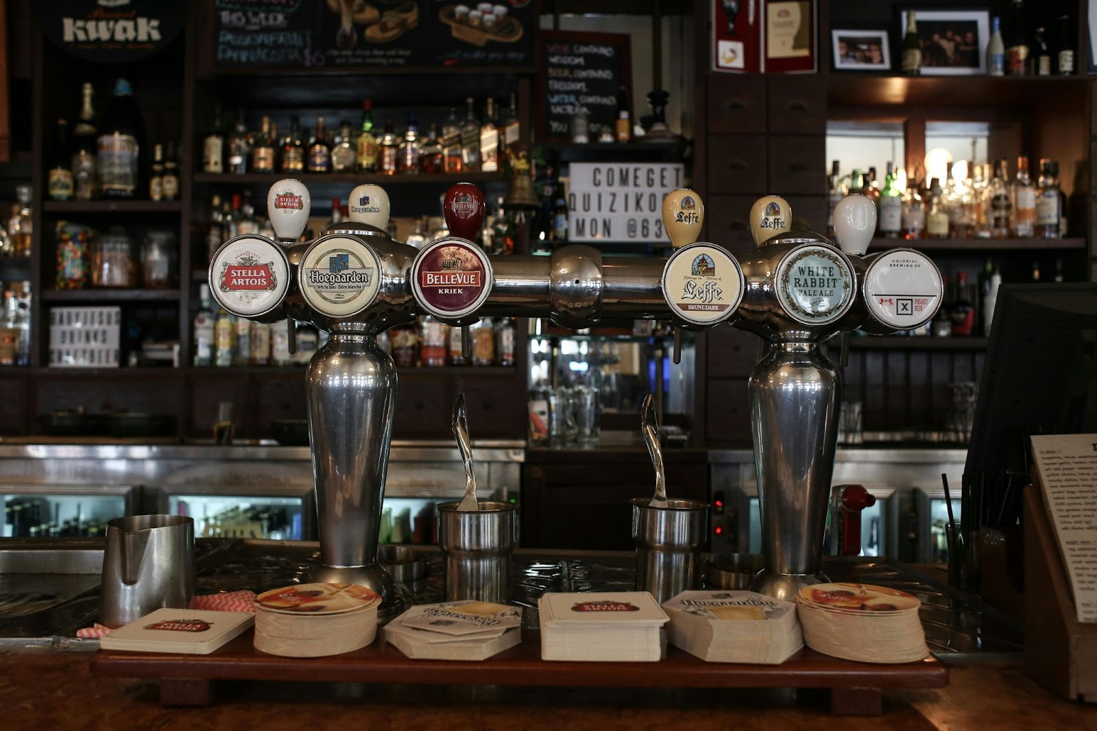 A bar counter showcasing beer taps, featuring popular brands, representing Cincinnati's brewing history and its vibrant beer culture.