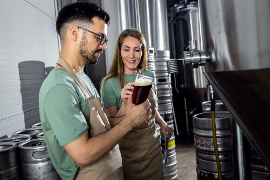 Two brewers inspect a freshly brewed beer, showcasing the craft of Cincinnati breweries.