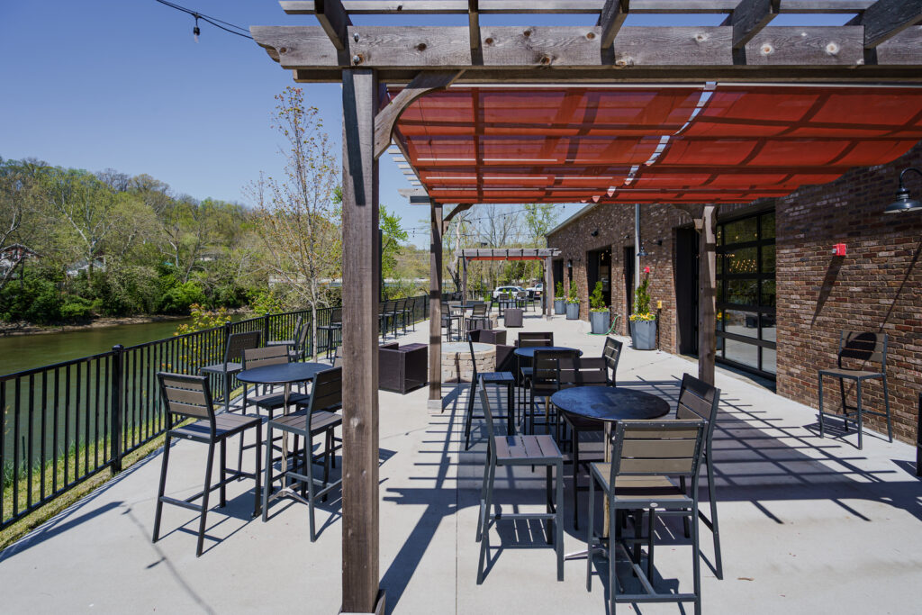 Little Miami Brewing Company’s riverside outdoor patio with guests enjoying drinks and seating in a relaxed atmosphere.