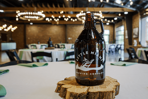 A large beer bottle with the Little Miami Brewing Company logo on a table in a restaurant.