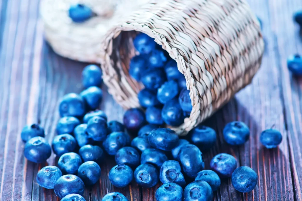 Fresh blueberries spilling from a wicker basket