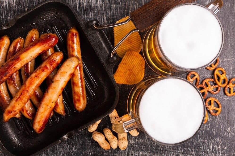 Grilled sausages, pretzels, and beer - the perfect party event spread.