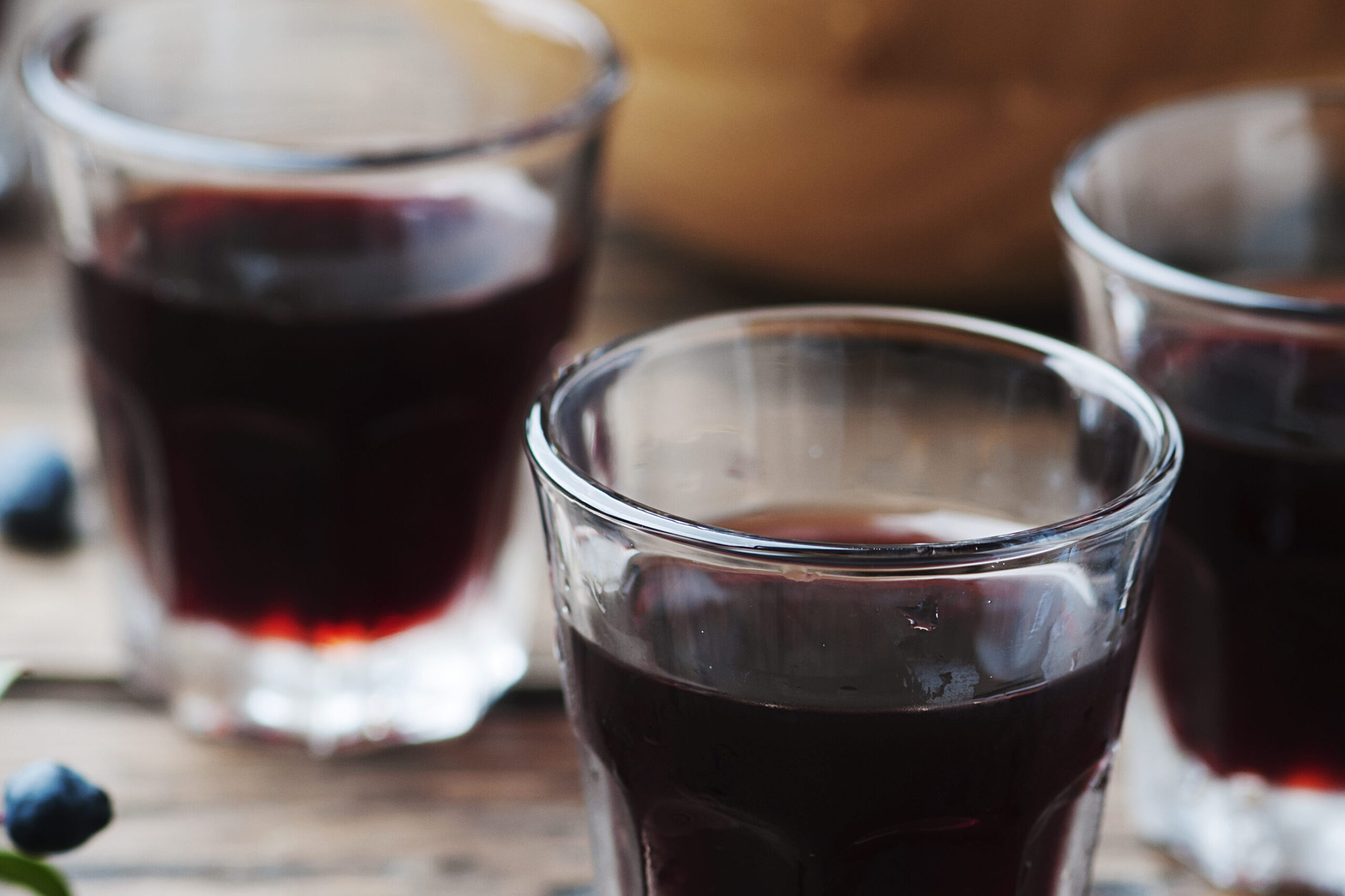 Close-up of glasses filled with rich, dark blueberry beer, capturing its vibrant color and inviting appeal for wine enthusiasts.