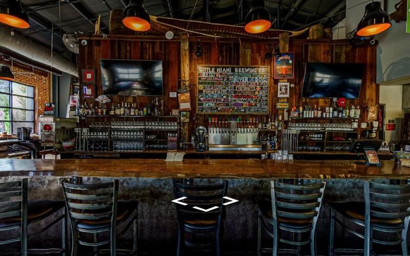 Rustic craft brewery bar with wooden finishes, chalkboard beer menu, and a variety of taps.