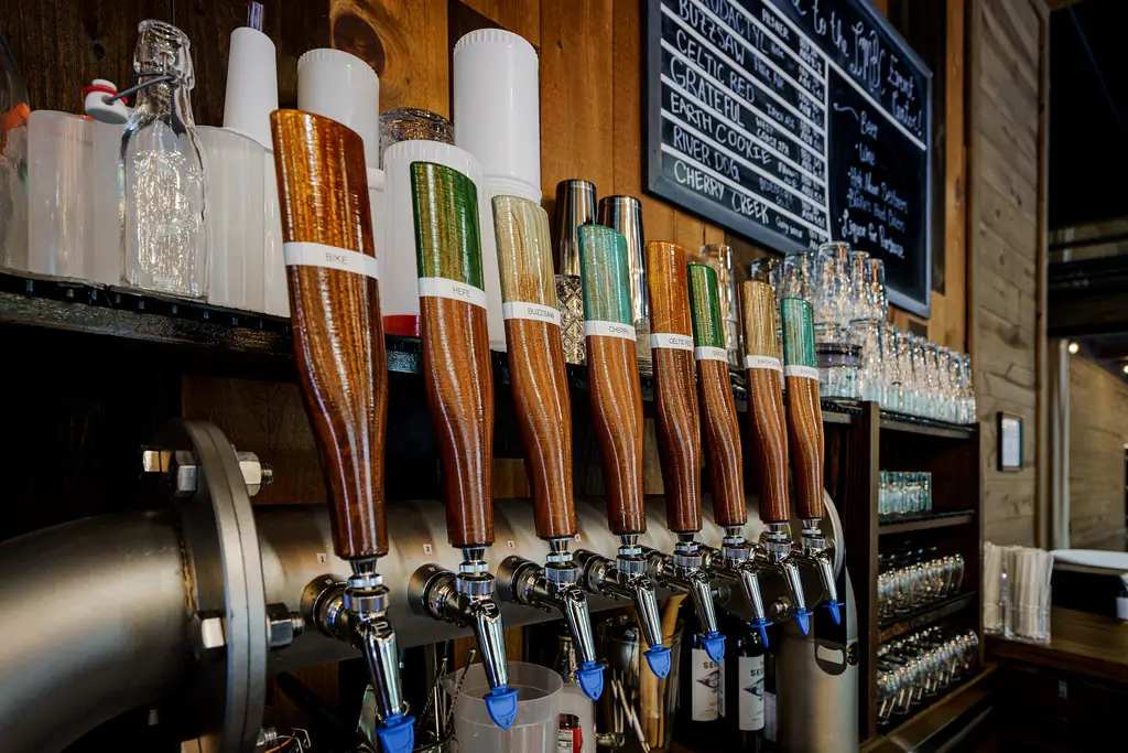 A close-up of a bar with several beer taps