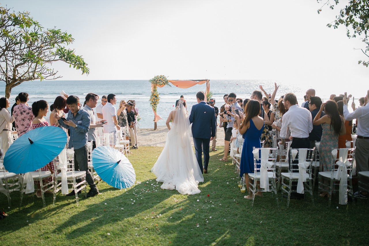 Outdoor beach wedding ceremony setup with guests facing the ocean, ideal for a coastal-themed wedding celebration.