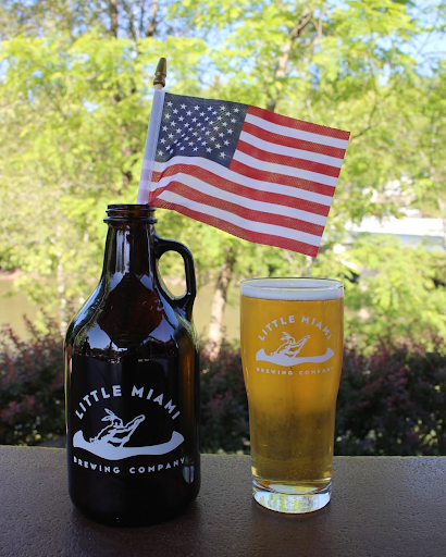A beer growler and glass of Little Miami Brewing beer with an American flag.