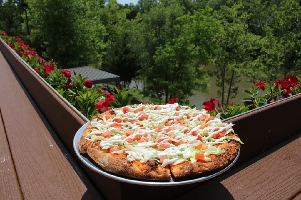 Freshly baked Carlito Pizza topped with spicy chorizo, sour cream, and crisp vegetables at Little Miami Brewing Company.