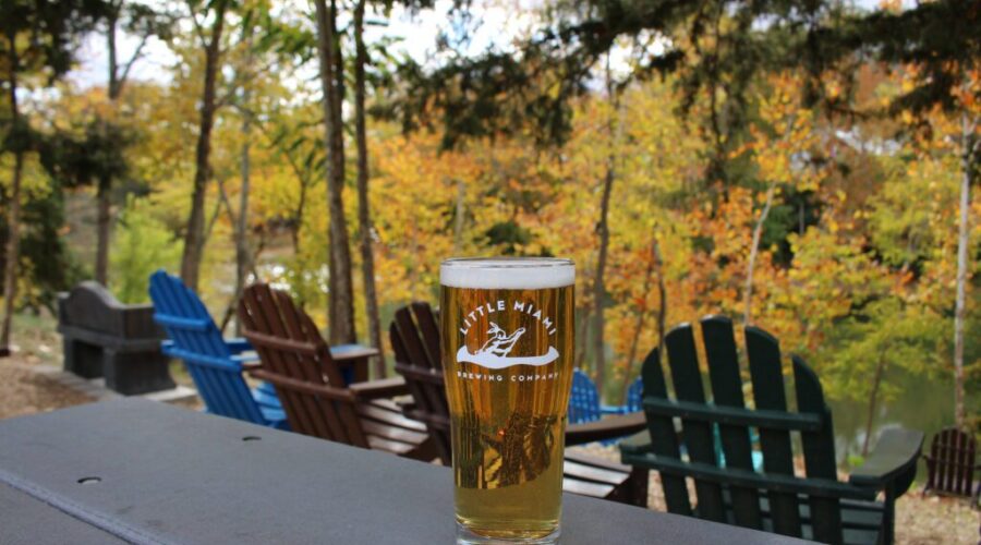 LMBC Bike Path Pilsner on a table with river view and outdoor seating in Cincinnati.