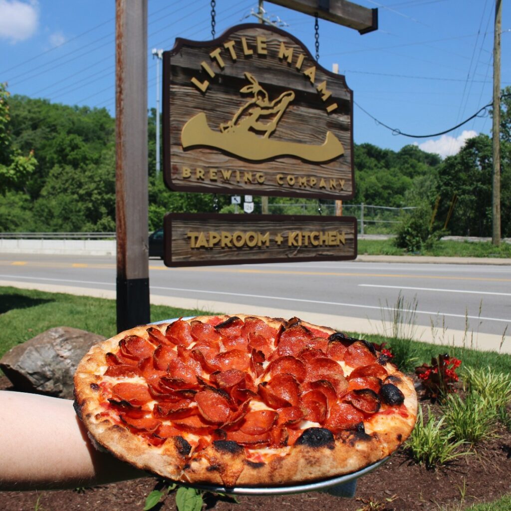 Double Pepperoni “Peppalicious” pizza served fresh under the Little Miami Brewing Company signboard.