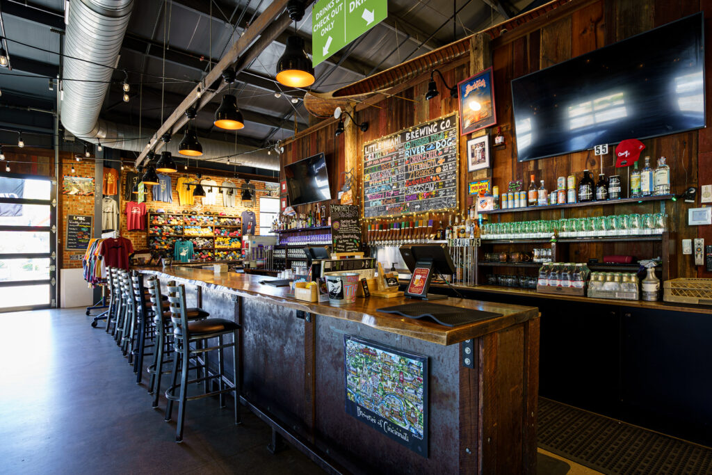 Interior of Little Miami Brewing Company taproom with rustic tables and brewery décor.