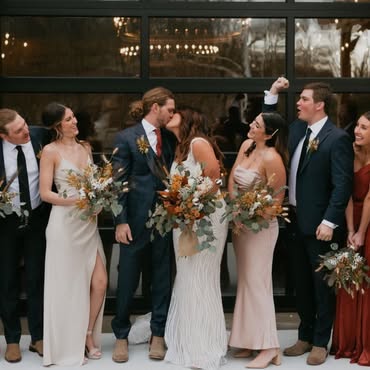Bride and groom kissing in front of their wedding party at Little Miami Brewing Company.