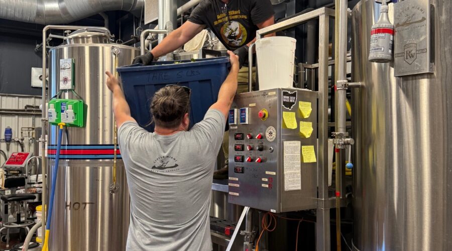 Two brewers working around a large brewing system at Little Miami Brewing Company.