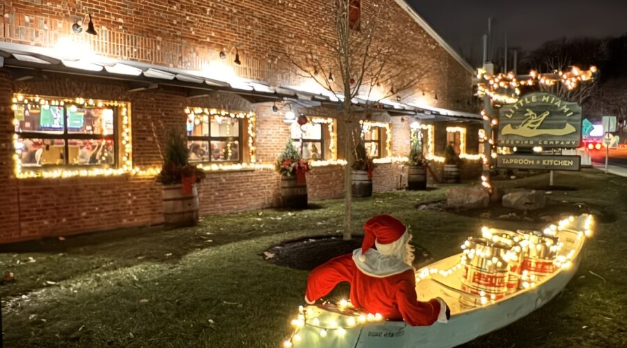 Little Miami Brewing Company exterior decorated with Christmas lights, with Santa sitting in a festive canoe out front.