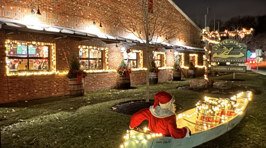 Little Miami Brewing Company exterior decorated with Christmas lights, with Santa sitting in a festive canoe out front.