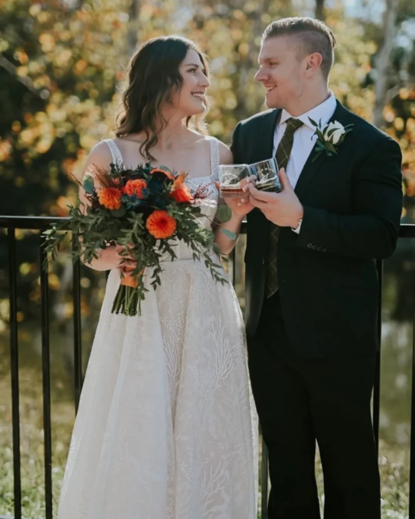 Newlyweds sharing a romantic toast with craft beer at Little Miami Brewing Company's riverside wedding venue.