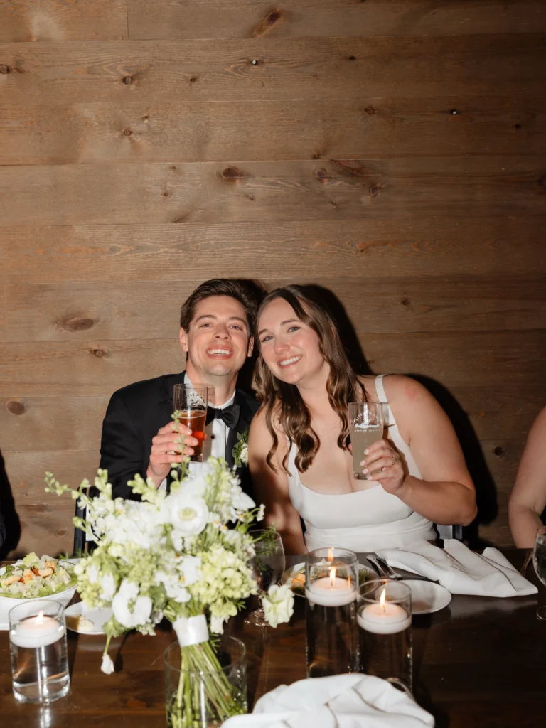 Bride and groom smiling with craft beer glasses while celebrating their wedding reception at Little Miami Brewing Company.
