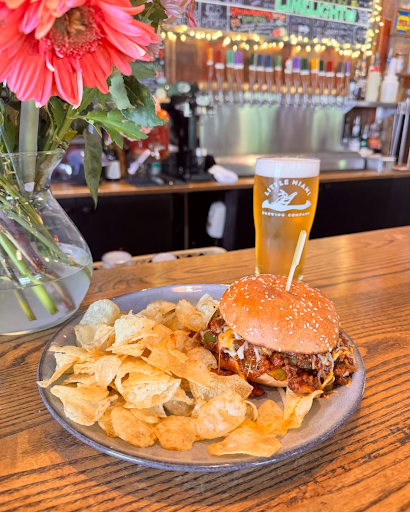 A fresh sandwich served with chips and a pint of craft beer at Little Miami Brewing Company, highlighting casual dining for birthday celebrations.