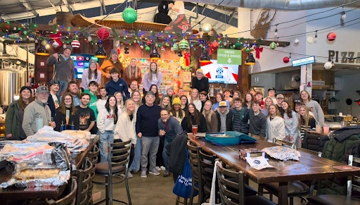 A large group of guests enjoying a milestone birthday celebration inside the lively taproom at Little Miami Brewing Company.