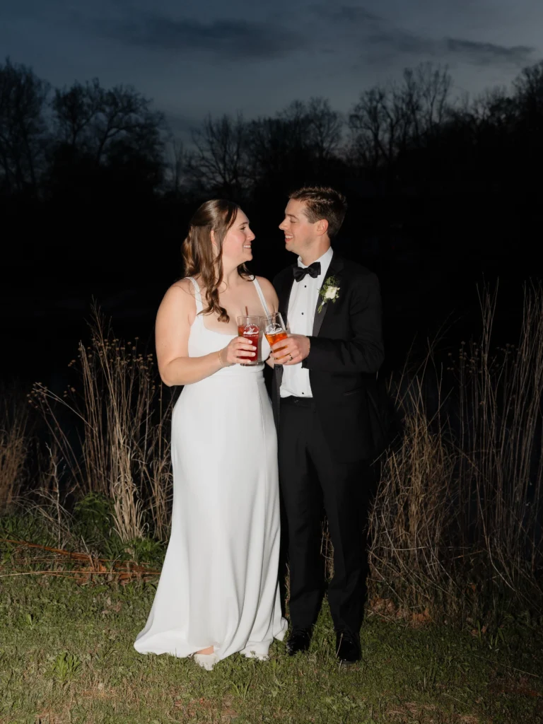 Bride and groom toasting with craft beer during the night outside at Little Miami Brewing Company.