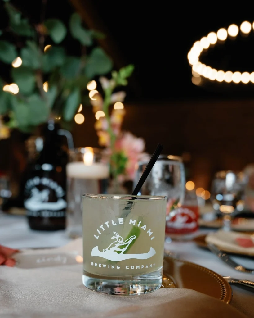 Little Miami Brewing Company cocktail in branded glassware at a rehearsal dinner venue setup.