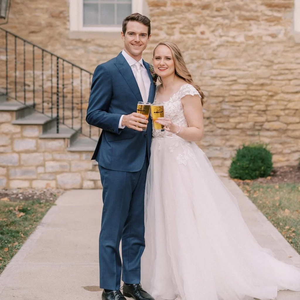 Bride and groom holding craft beers outside at Little Miami Brewing Company.