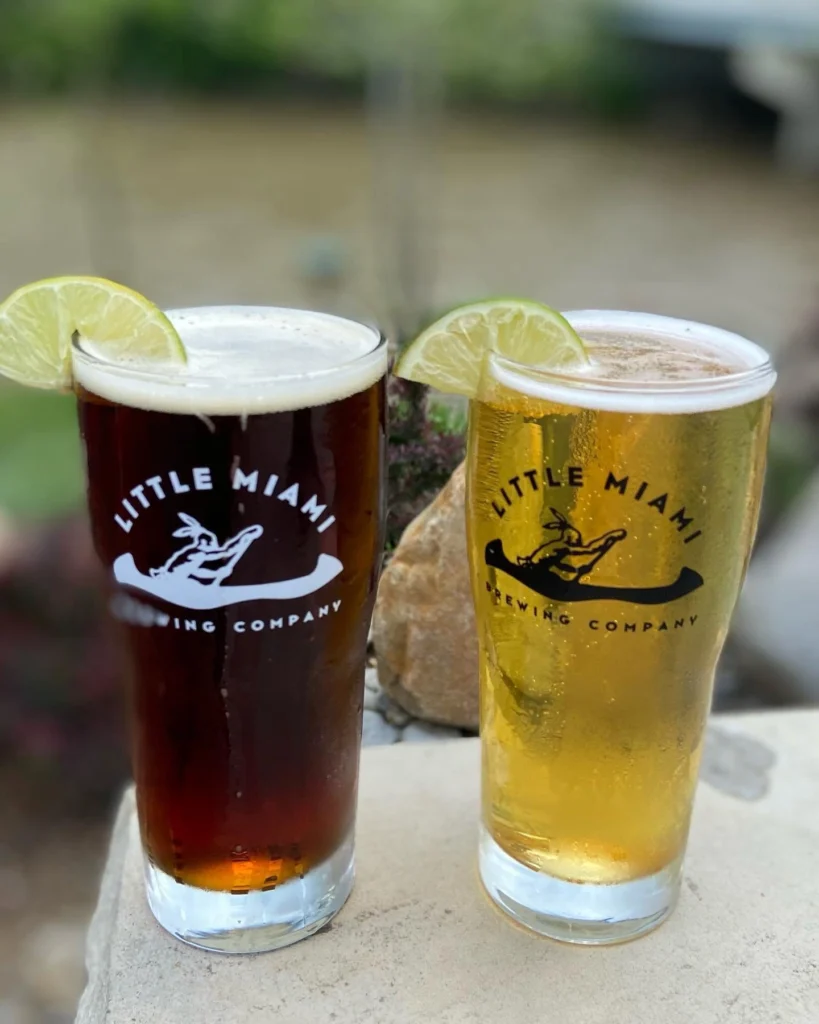 A dark beer and a pale craft beer side by side garnished with a lime at Little Miami Brewing Company.