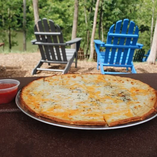 Cheesy gluten-free cauliflower crust pizza served with marinara sauce on an outdoor patio at Little Miami Brewing Co.